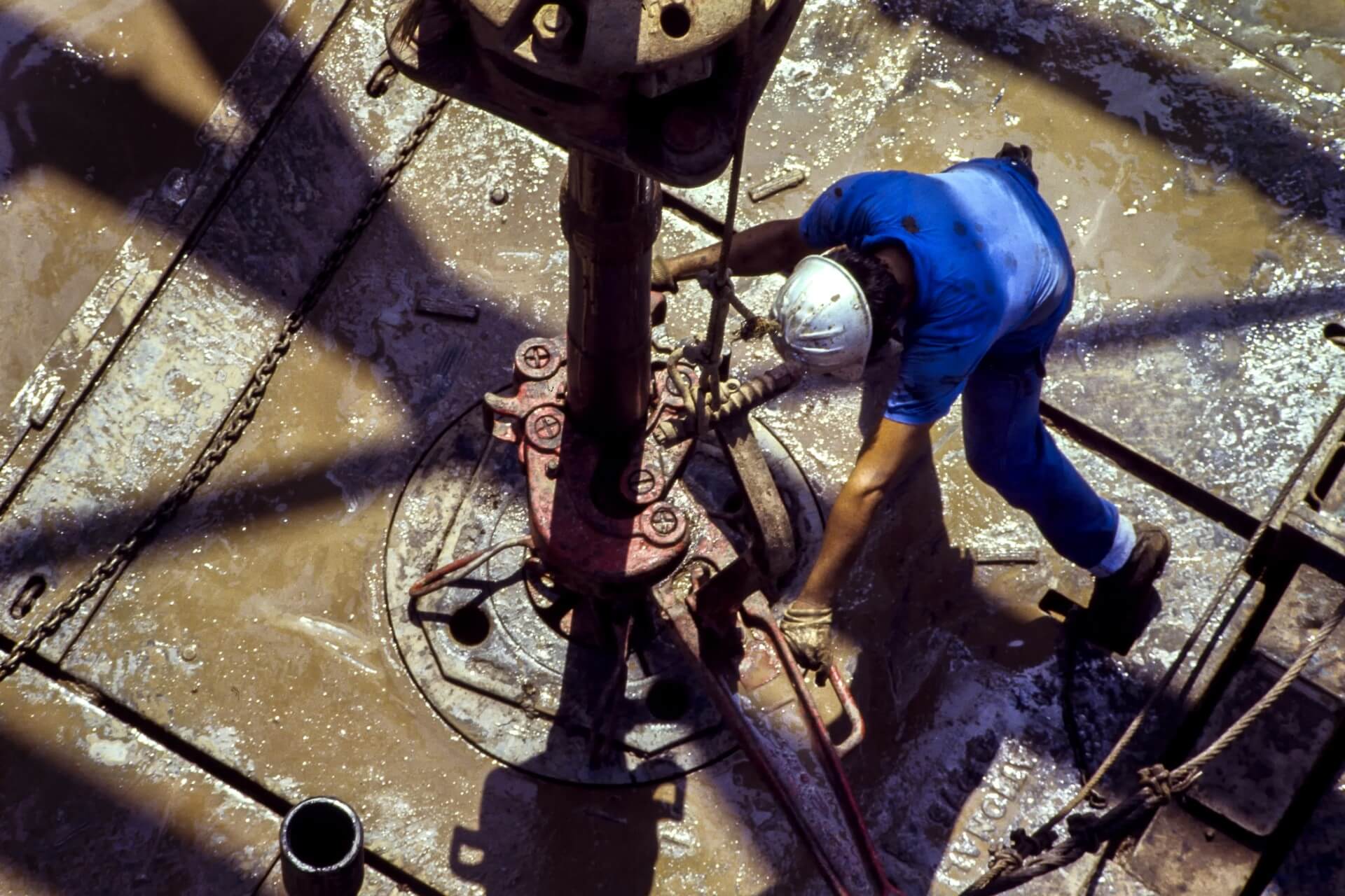 An oil worker adjusting a pumpjack.